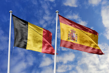 3d illustration. Belgium and Spain Flag waving in sky. High detailed waving flag. 3D render. Waving in sky. Flags fluttered in the cloudy sky.