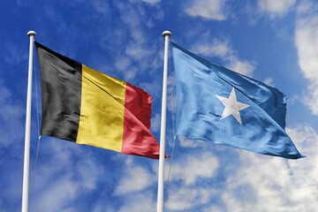 3d illustration. Belgium and Somalia Flag waving in sky. High detailed waving flag. 3D render. Waving in sky. Flags fluttered in the cloudy sky.