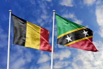 3d illustration. Belgium and Saint Kitts and Nevis Flag waving in sky. High detailed waving flag. 3D render. Waving in sky. Flags fluttered in the cloudy sky.