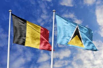 3d illustration. Belgium and Saint Lucia Flag waving in sky. High detailed waving flag. 3D render. Waving in sky. Flags fluttered in the cloudy sky.