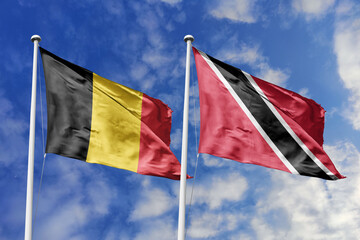 3d illustration. Belgium and Trinidad and Tobago Flag waving in sky. High detailed waving flag. 3D render. Waving in sky. Flags fluttered in the cloudy sky.