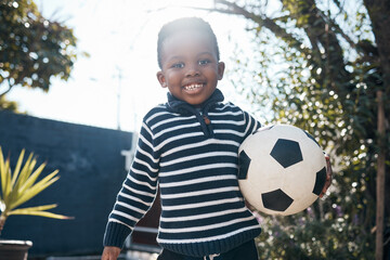 Portrait, smile and African child with soccer ball outdoor for sport, exercise and playing at...