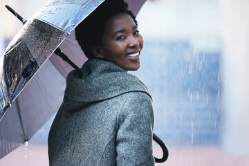 Portrait, smile and African businesswoman with umbrella for rain, cover and travel in city for work. Water, weather and employee in street with insurance, protection and walking in New York in winter - Powered by Adobe