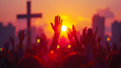 People raising hands in worship at sunset with city silhouette and cross