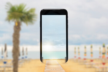Mobile phone screen with beach umbrellas on the sandy beach