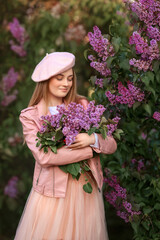 beautiful spring girl in a pink jacket and pink skirt with a bouquet of lilacs on a walk