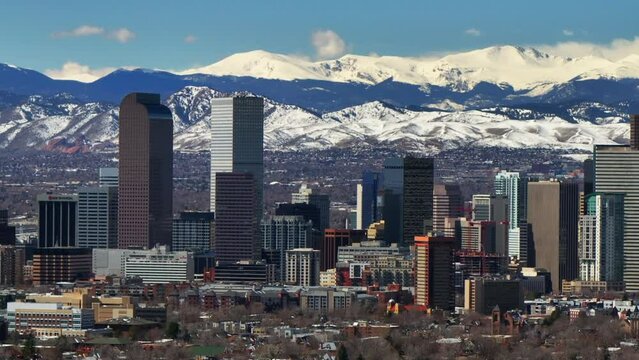 City Park parallax Downtown Denver Colorado aerial drone neighborhood streets Spring Mount Blue Sky Evans Front Range Rocky Mountains foothills skyscrapers daytime sunny clouds circle left