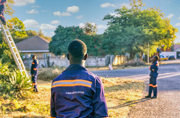 installing optic fiber outdoors, three african technicians, in residential home area
