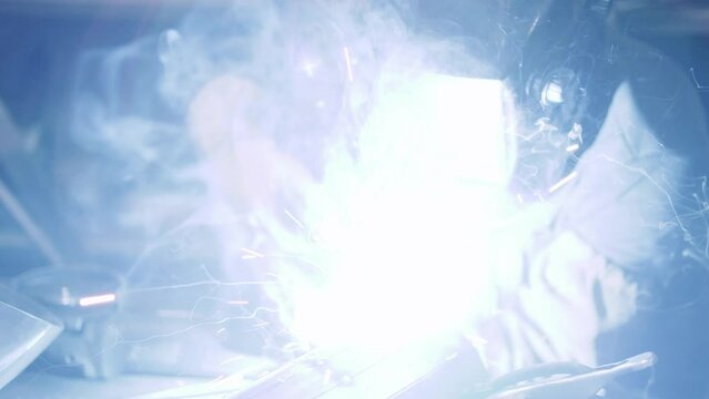 Artisan uses a welding machine to connect two pieces of metal together.