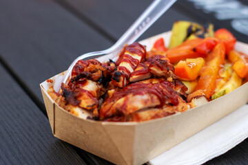 Fast food container with chicken, vegetables, and fork for convenience