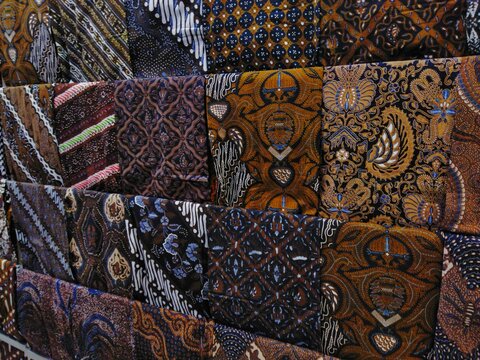 Jarik cloth with various motifs hanging in a modern shop is taken from the side