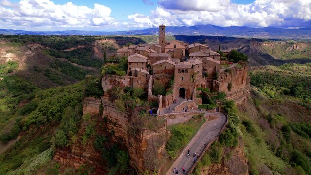 One of the most beautiful italian villages Breathtaking Civita di Bagnoregio. Aerial 4K Italy ghost town. Cinematic drone over medieval hilltop town in tuff rock with bridge. Ancient Lazio 