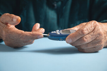 Elderly woman checking her blood sugar level.