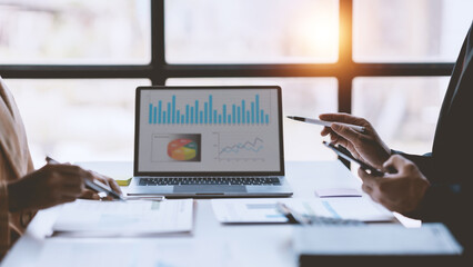 Business representatives meeting pointing on laptop computer. Business team discussing investment plan using data on laptop.