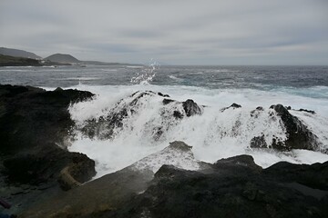 Rocky shore with turbulent waves crashing onto the rugged coastline