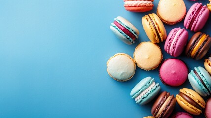 Obraz premium Colorful macarons arranged on blue background