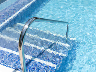 Shiny Metal Pool Ladder in Clear Blue Water