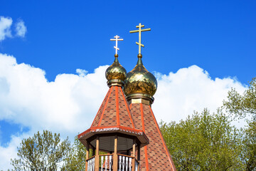 A church building with two gold crosses on top of its steeple against the sky