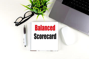BALANCED SCORECARD text on notebook with laptop, mouse and pen