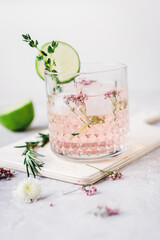 natural cocktail with herbs and cut lime on stone desk background