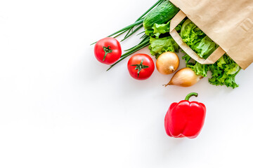 Healthy food with fresh vegetables in paper bag on white backgro