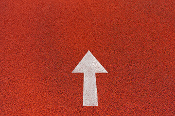 Colorful asphalt texture in the athletics stadium or road with white paint arrow means keep forward.