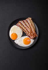 English breakfast with fried eggs, bacon, beans, tomatoes, spices and herbs