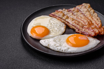 English breakfast with fried eggs, bacon, beans, tomatoes, spices and herbs