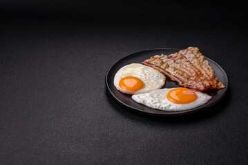 English breakfast with fried eggs, bacon, beans, tomatoes, spices and herbs