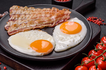 English breakfast with fried eggs, bacon, beans, tomatoes, spices and herbs