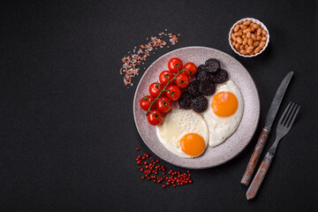 English breakfast with fried eggs, bacon, beans, tomatoes, spices and herbs