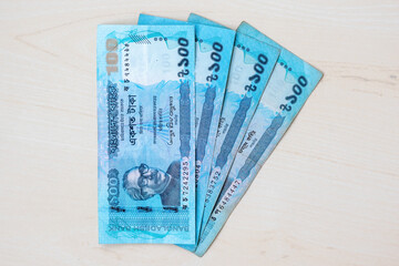 Bangladeshi currency BDT 100 taka note isolated on wooden background.