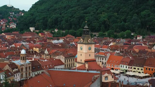 Gorgeous aerial perspective of a charming European BRASOV town featuring a clock tower and vibrant red rooftops