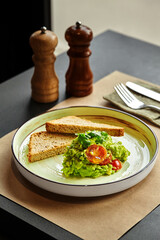 Piquant guacamole with cherry tomatoes, herbs and toasts