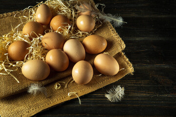 A pile of chicken eggs with straw and feathers. Eggs are collected to make a healthy breakfast or dinner. Advertising space