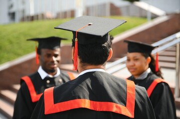 Diverse international students with diplomas at university campus