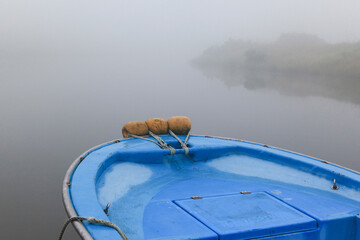 View of the motor boat on the foggy lake
