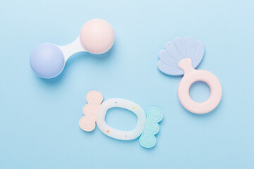Colorful baby rattles and toys on color background, top view
