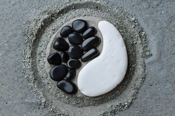 Obraz premium Yin Yang Black and White Stones on Grey Sand Background