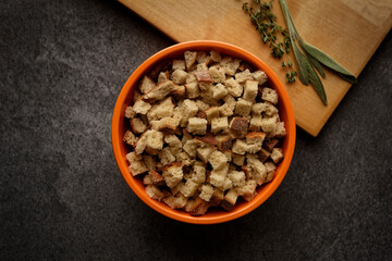 Top view of bowl of croutons on a wooden cutting board