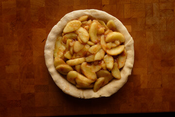 Top view of a pie crust filled with apple slices, ready for baking