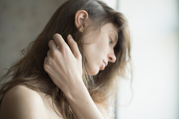 Fototapeta premium portrait of a girl on a light background long blond hair light skin