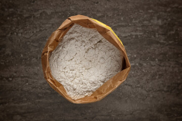 Top view of a brown paper bag of white flour on a table