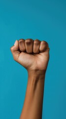 Raised Fist of Resilience and Power Against Blue Background