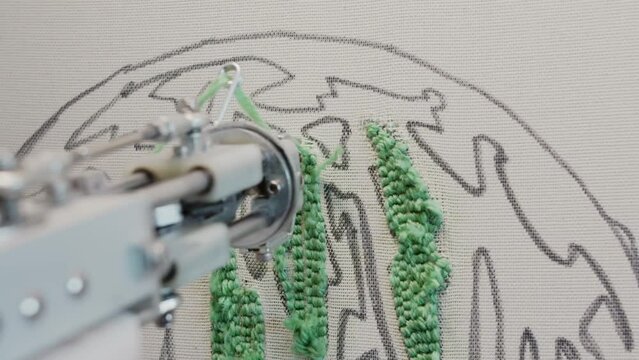 close-up view of a tufting machine in use, as it stitches a carpet with yarn. Slow motion.