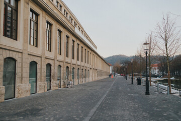 Naklejka premium Empty sidewalk with light poles and buildings in the background. Ljubljana, Slovenia