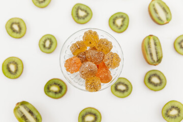 Tasty candied fruit jelly with kiwi fruits on white. Flat lay, top view.