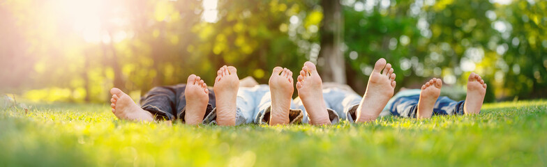 Family of for lying down on the meadow with naked feet.