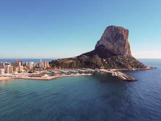 Naklejka premium Scenic rocky beach by the ocean with Spanish architecture: Spain, Calpe
