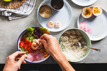 Poke bowl with shrimp prepared by the chef containing white rice, mango, avocado, tomato, etc.